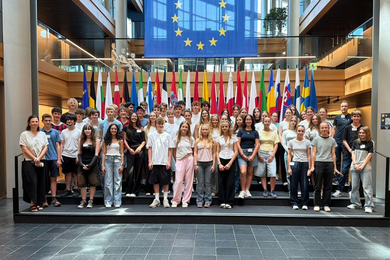 Schüler und Schülerinnen der Jahrgansstufe 10 vor den Flaggen der EU-Mitgliedsstaaten im Europaparlament